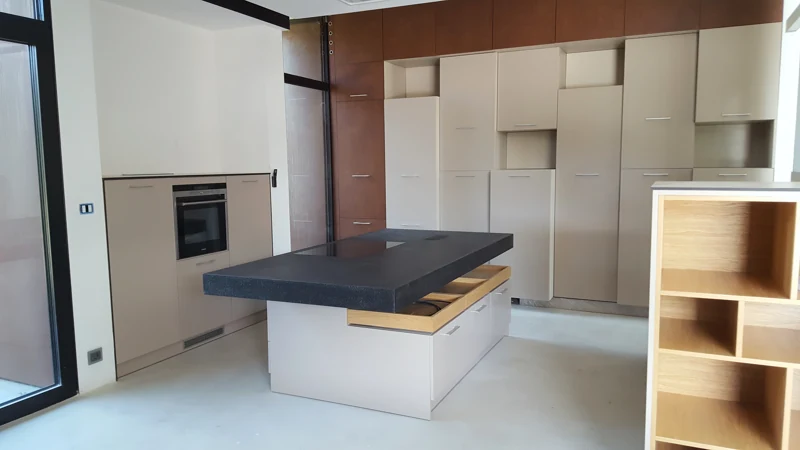 Kuchnia z wyspą i sąsiadującą zabudową — meble wykonane przez BK76 w domu pod Wrocławiem