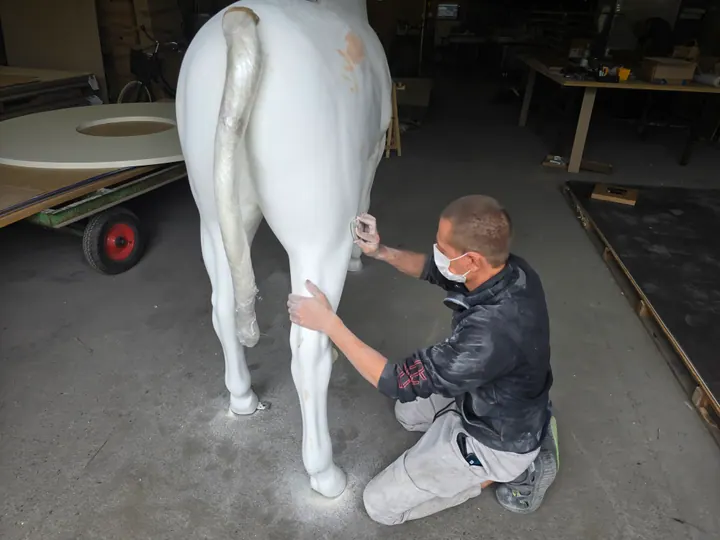 Préparation manuelle de la surface de la sculpture de cheval avant laquage