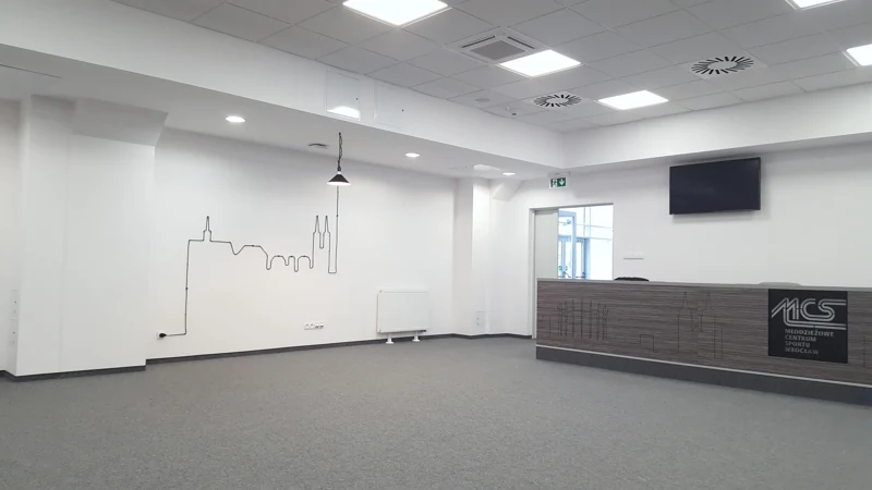 Wnętrze z lampą i stołem z oznaczeniem MCS — realizacja BK76
